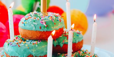 stack of green frosted doughnuts with first birthday candle