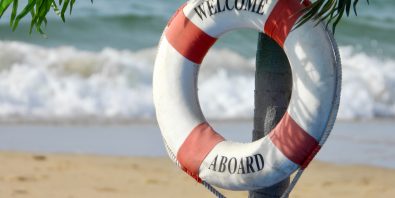 Photo of beach with lifebuoy that says "Welcome Aboard" Photo by Nick Fewings on Unsplash